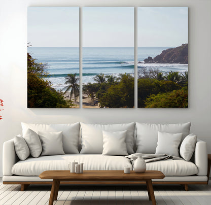 View of calm ocean waves with palm trees and a tropical coastline, ideal for coastal boho or beach-themed wall decor.