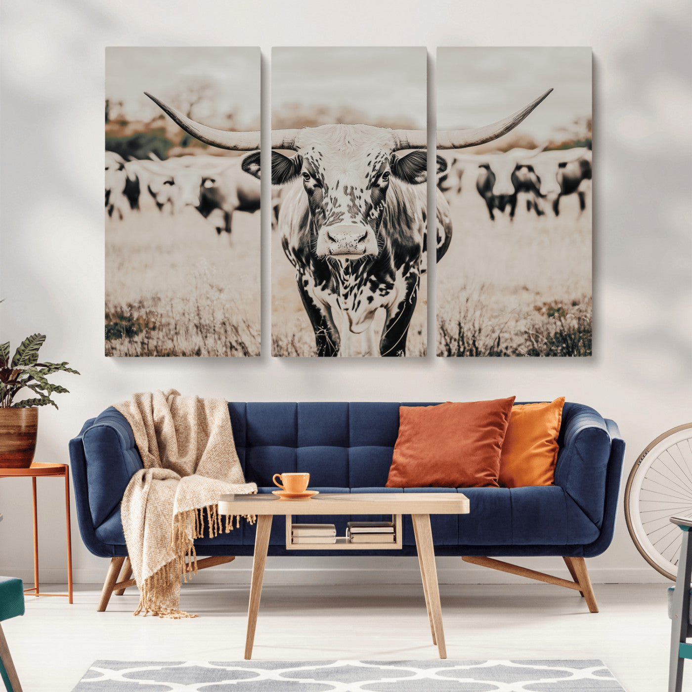 Canvas of a speckled Texas longhorn standing boldly in a field with a herd behind, perfect for rustic western or farmhouse wall decor.