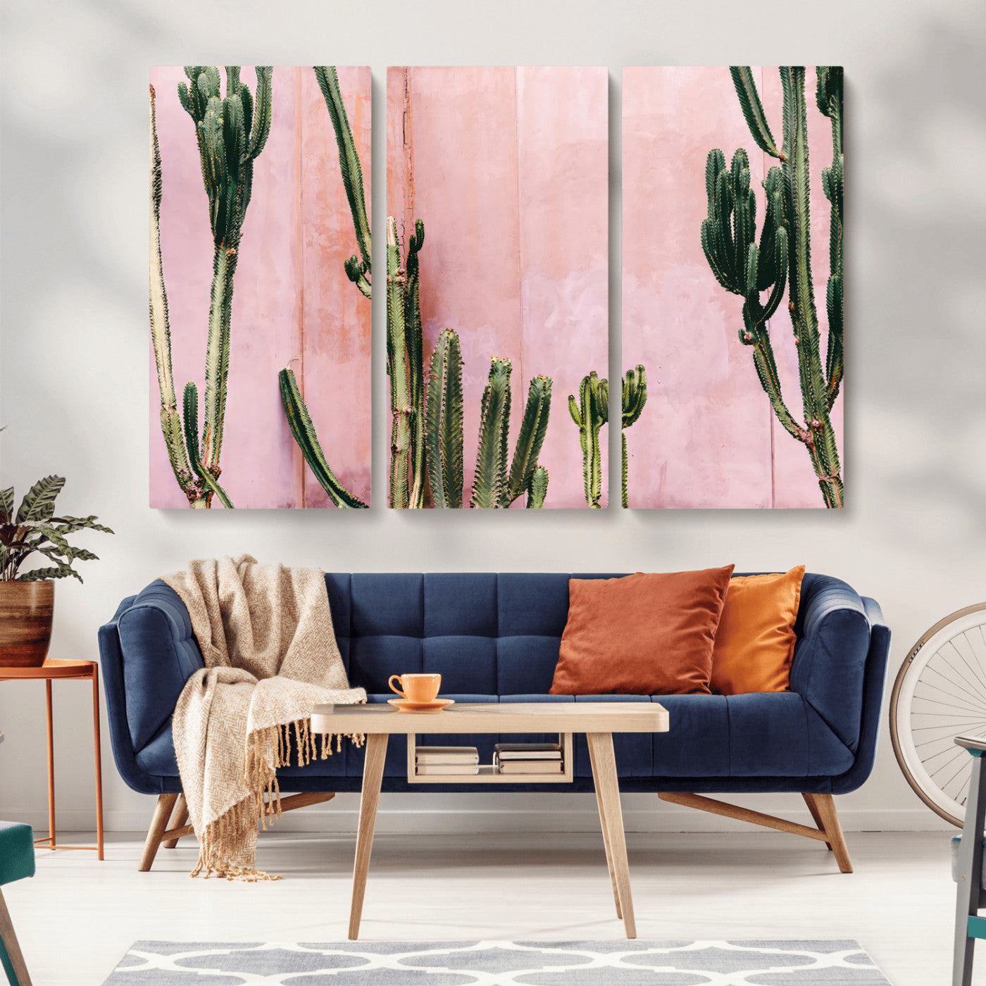 Framed canvas of tall green cacti against a soft pink wall, ideal for modern desert or colorful southwest-inspired home decor.