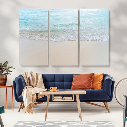Soft shoreline with gentle aqua waves on smooth sand, ideal for minimalist coastal or pastel ocean-inspired home wall decor.