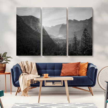 Black and white landscape of Yosemite with sun rays peeking over El Capitan, ideal for moody nature or modern rustic decor.