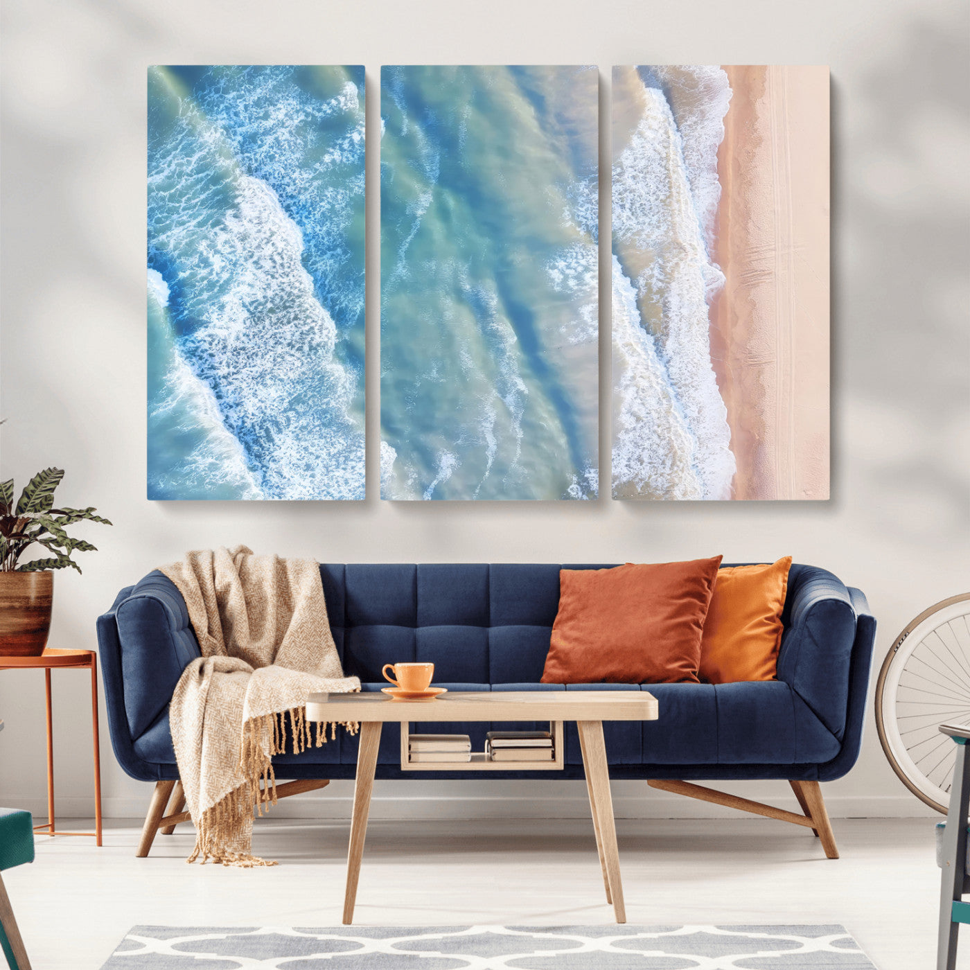 Aerial photo of soft blue waves meeting sandy shore, perfect for modern coastal or beach-themed decor with a light and tranquil aesthetic.
