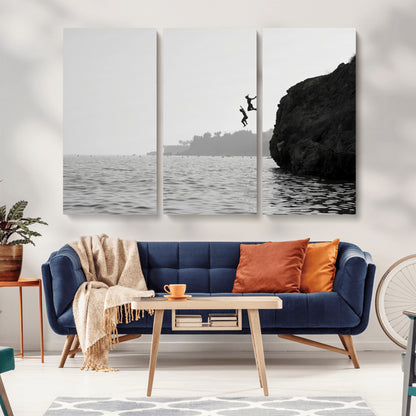 Black and white canvas of two figures cliff jumping into the sea, captured with moody tones, ideal for modern coastal or adventure-themed home decor.   2/2