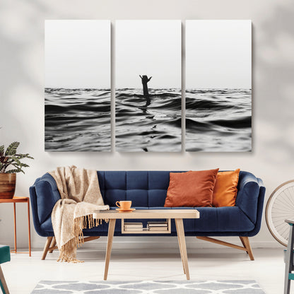 Black and white ocean with a hand making a surfer sign among dark waves, creating a dramatic and minimalist seascape with bold contrast.