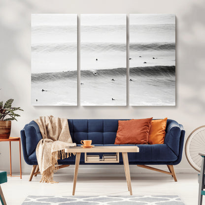 A monochrome photograph of swimmers gliding through gentle ocean waves, evoking a sense of calm and movement.