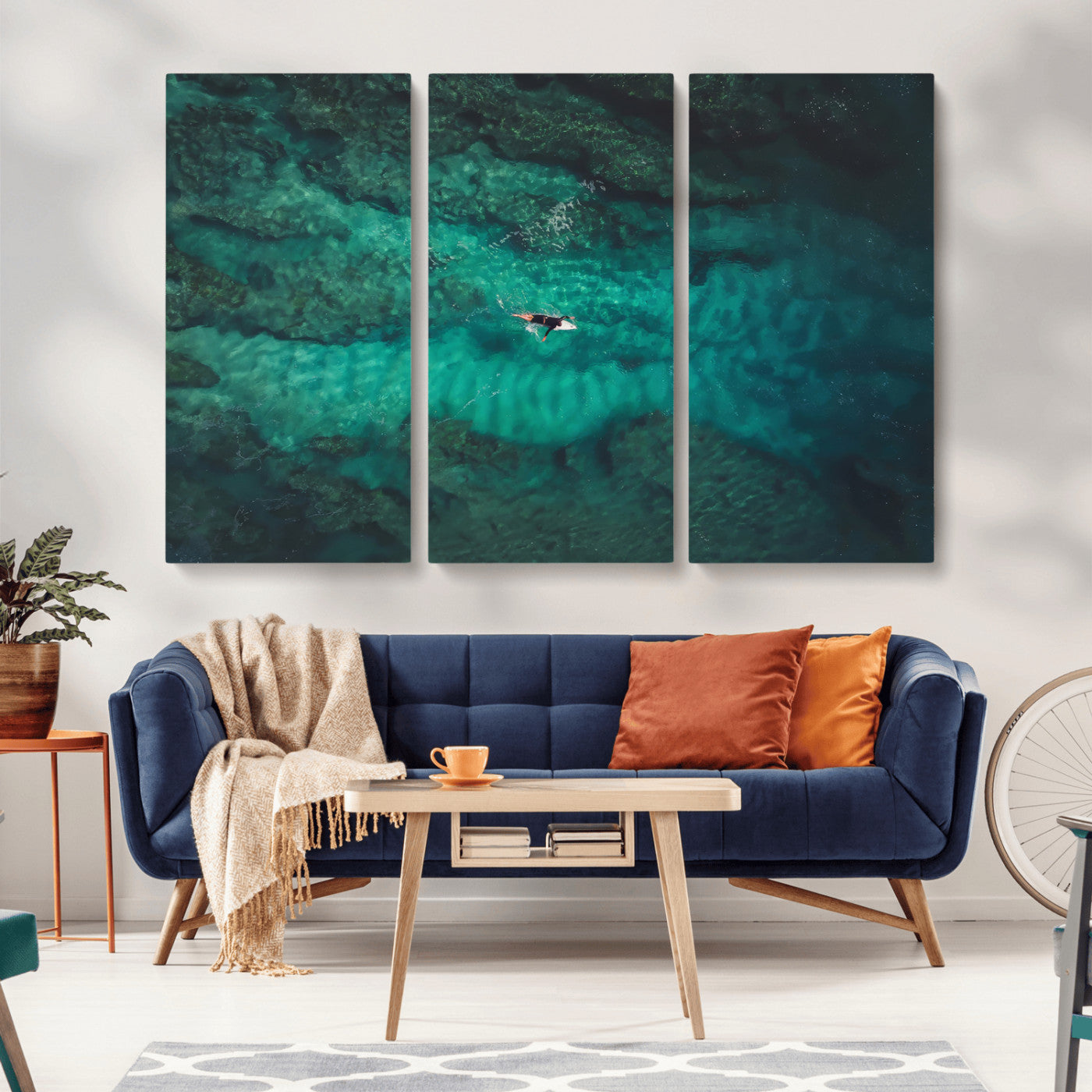 An aerial view of a solo surfer paddling through crystal-clear turquoise waters over a sunlit reef, capturing the beauty and serenity of open water surfing.