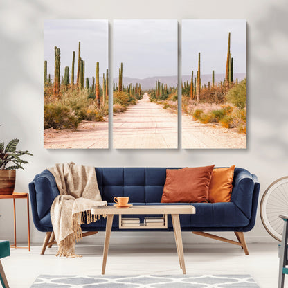 A desert road lined with saguaro cacti under a golden sky, creating a warm southwestern feel, perfect for boho or rustic decor.