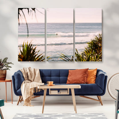 Canvas of a lone surfer riding a pastel wave at sunrise, perfect for tropical or coastal-themed spaces with a relaxed, airy vibe.