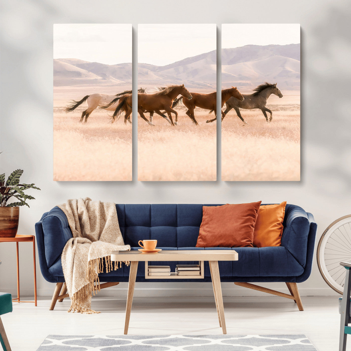 A herd of wild horses galloping through a sunlit desert plain with mountains in the background, perfect for rustic or western-themed wall decor.
