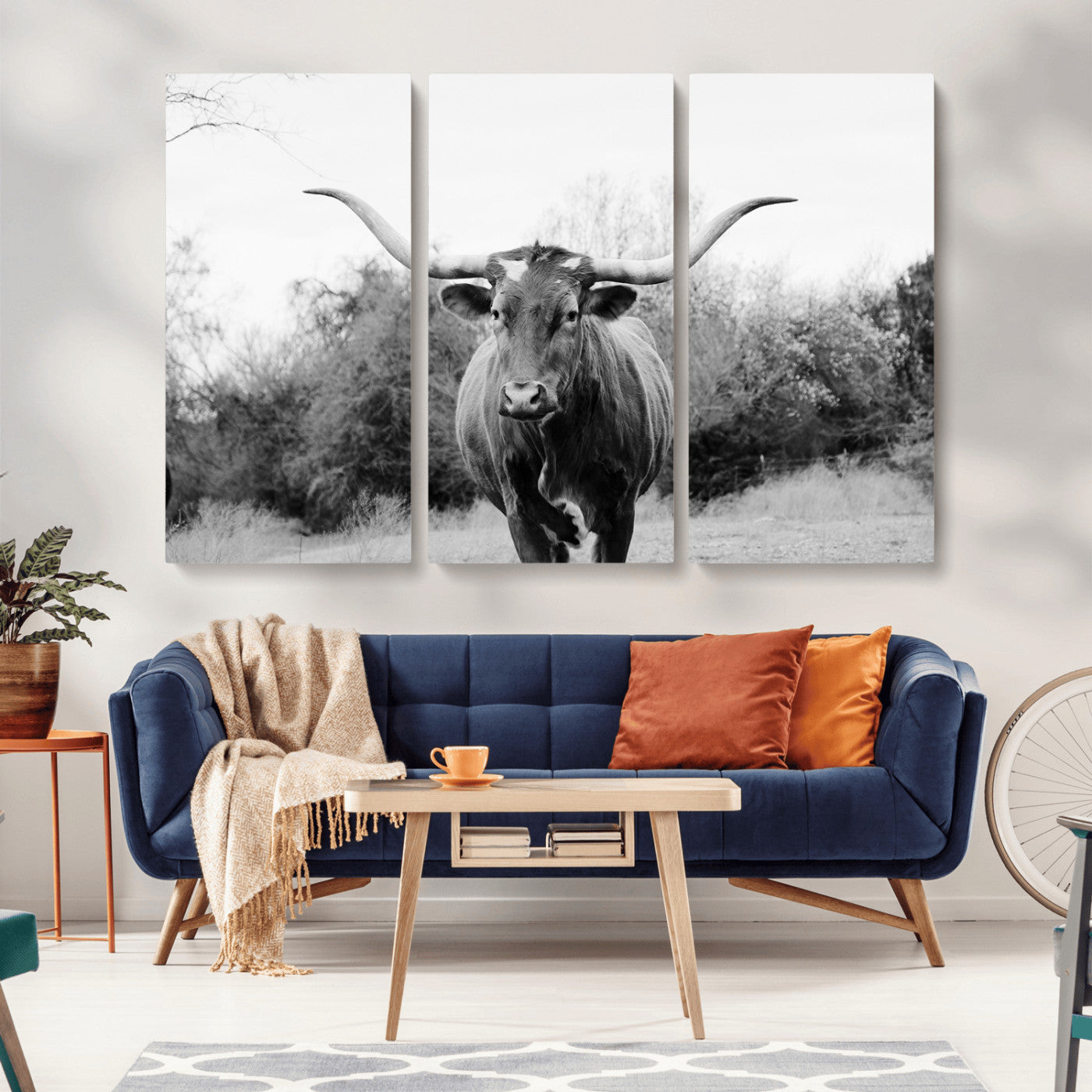 Black and white photo of a longhorn cow in a field, perfect for rustic farmhouse or western-themed interior wall decoration.