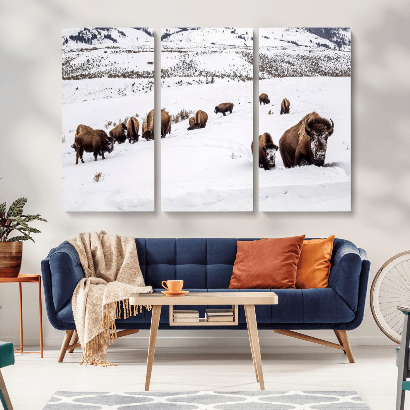 A herd of bison walking through deep snow in a mountain valley, perfect for rustic, cabin or western-themed wall decor.