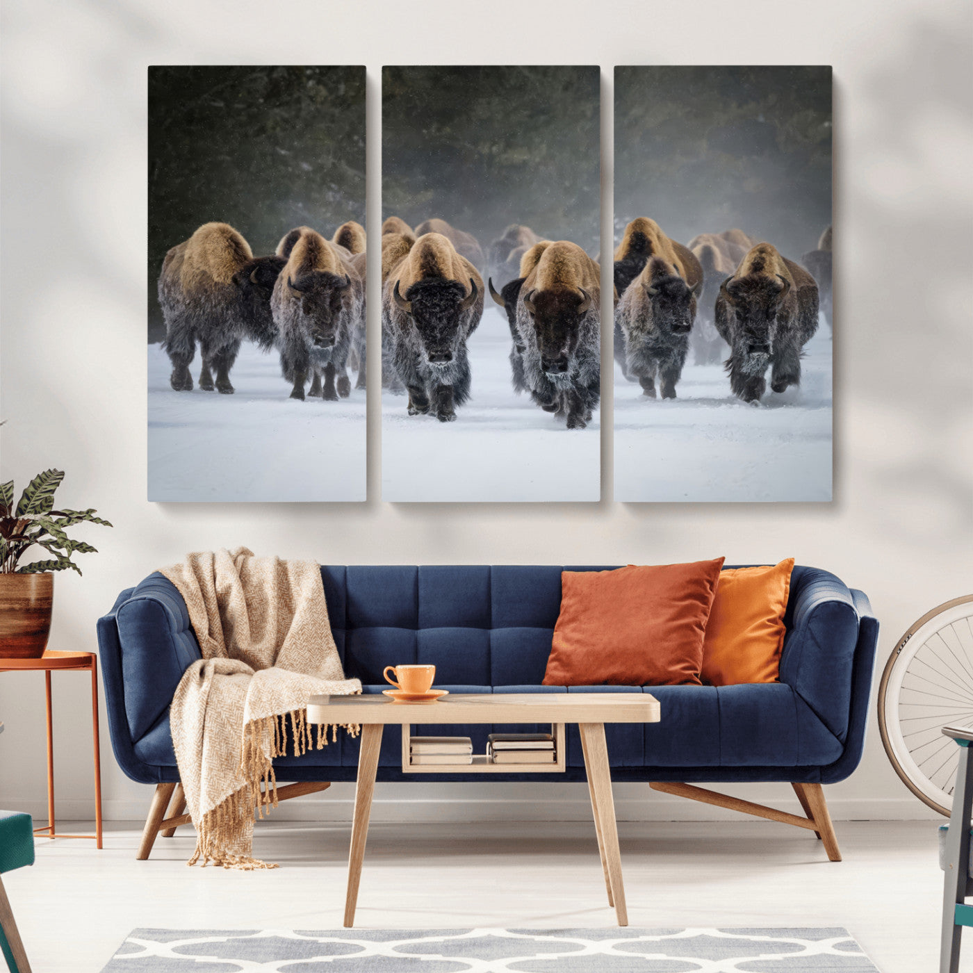 A herd of American bisons walking through deep snow in a forest, evoking a powerful rustic wilderness mood for western-style interiors.