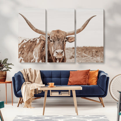 A longhorn cow in soft beige desert tones, standing calmly in open land, perfect for neutral western or rustic farmhouse interiors.