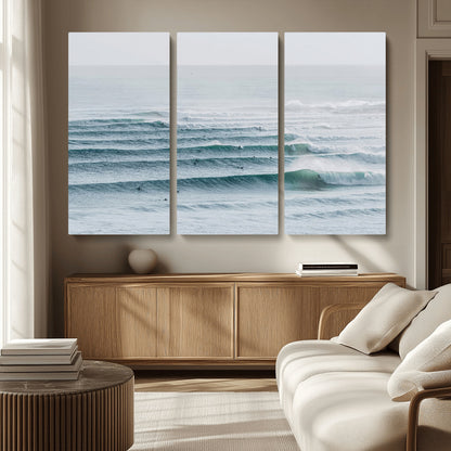 High-angle view of surfers lining up across layered ocean waves, ideal for minimal coastal or surf-inspired room decor.