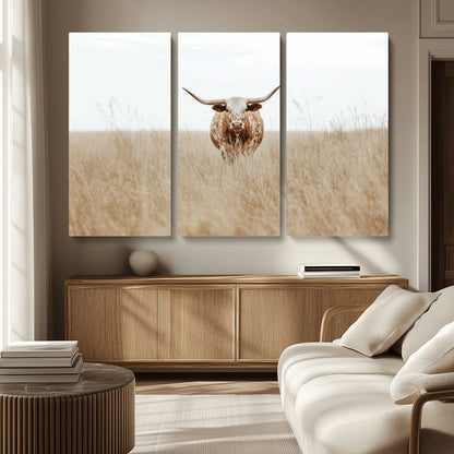 Texas Longhorn bull standing alone in dry grass with neutral tones, ideal for rustic western or cowboy-themed wall decor.