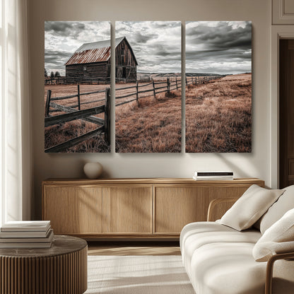 Framed canvas of a rustic barn under a moody sky with weathered fence and dark fields, ideal for farmhouse or rural-style wall decor.