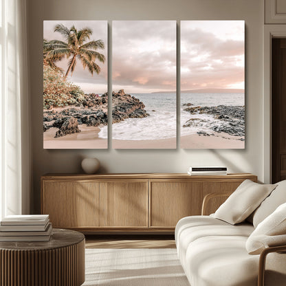 A peaceful beach scene with a palm tree and rocks, soft waves washing onto the shore under a soft pastel sky at sunset.