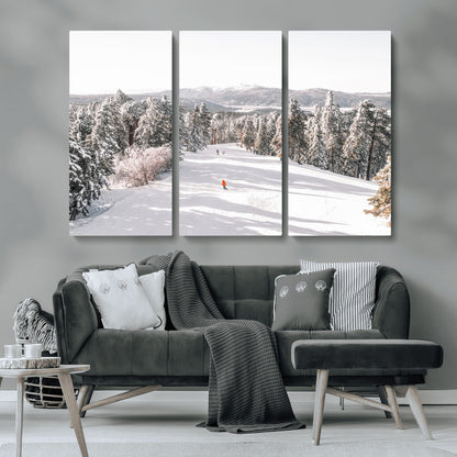 Bright ski trail lined with snow-covered pines and a skier in orange, perfect for alpine adventure or winter sports-inspired decor.