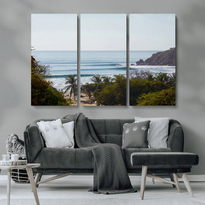 View of calm ocean waves with palm trees and a tropical coastline, ideal for coastal boho or beach-themed wall decor.