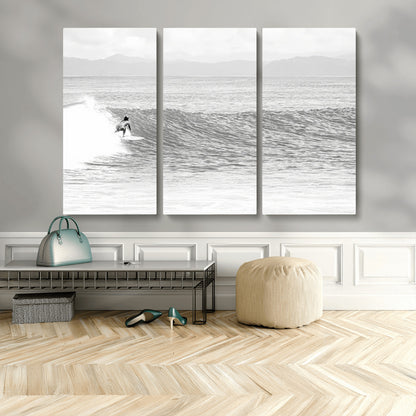 Monochrome photo of a surfer riding a wave with distant mountains, ideal for coastal motion or black and white surf-themed wall decor.