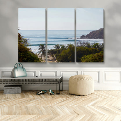View of calm ocean waves with palm trees and a tropical coastline, ideal for coastal boho or beach-themed wall decor.