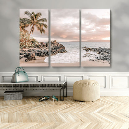 A peaceful beach scene with a palm tree and rocks, soft waves washing onto the shore under a soft pastel sky at sunset.