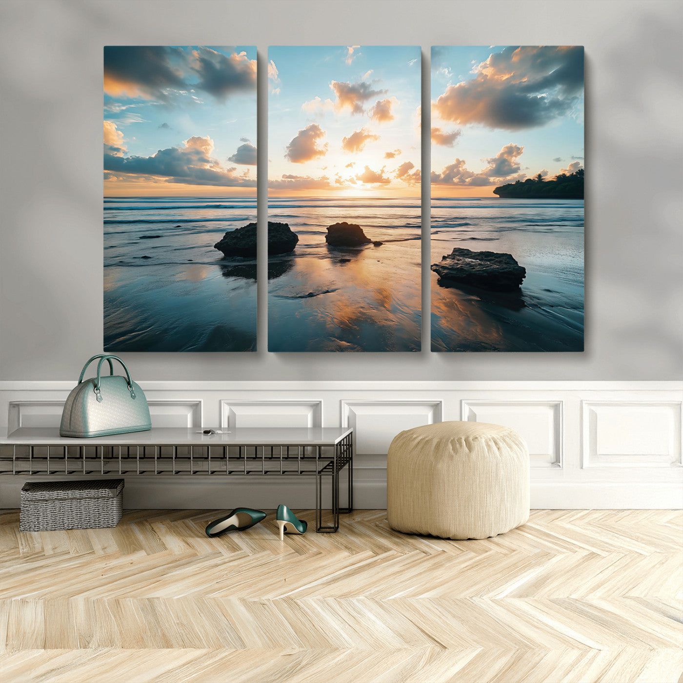 A serene beach at sunset with vibrant clouds, calm water, and rocks in the foreground reflecting the warm colors of the setting sun.