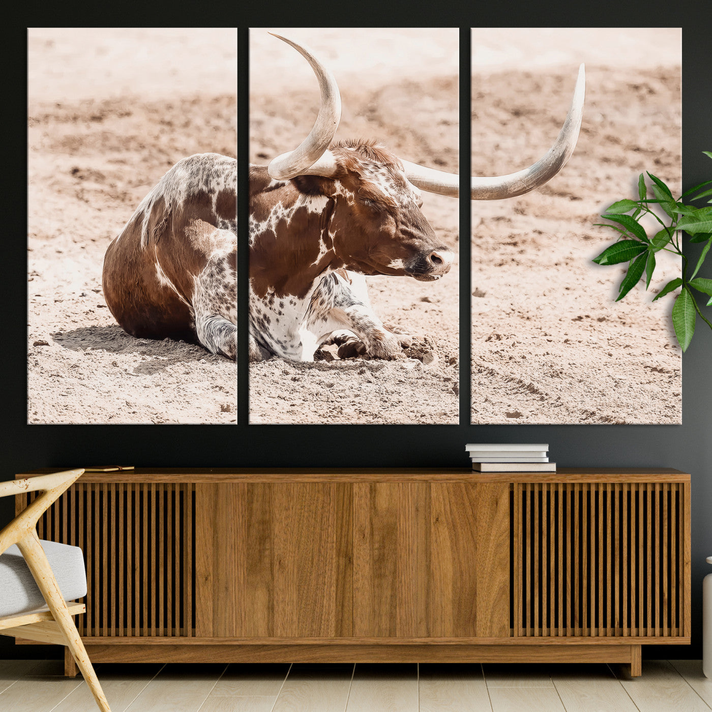 Texas Longhorn bull resting on dusty ground with warm tones, ideal for rustic western or farmhouse-themed wall decor.