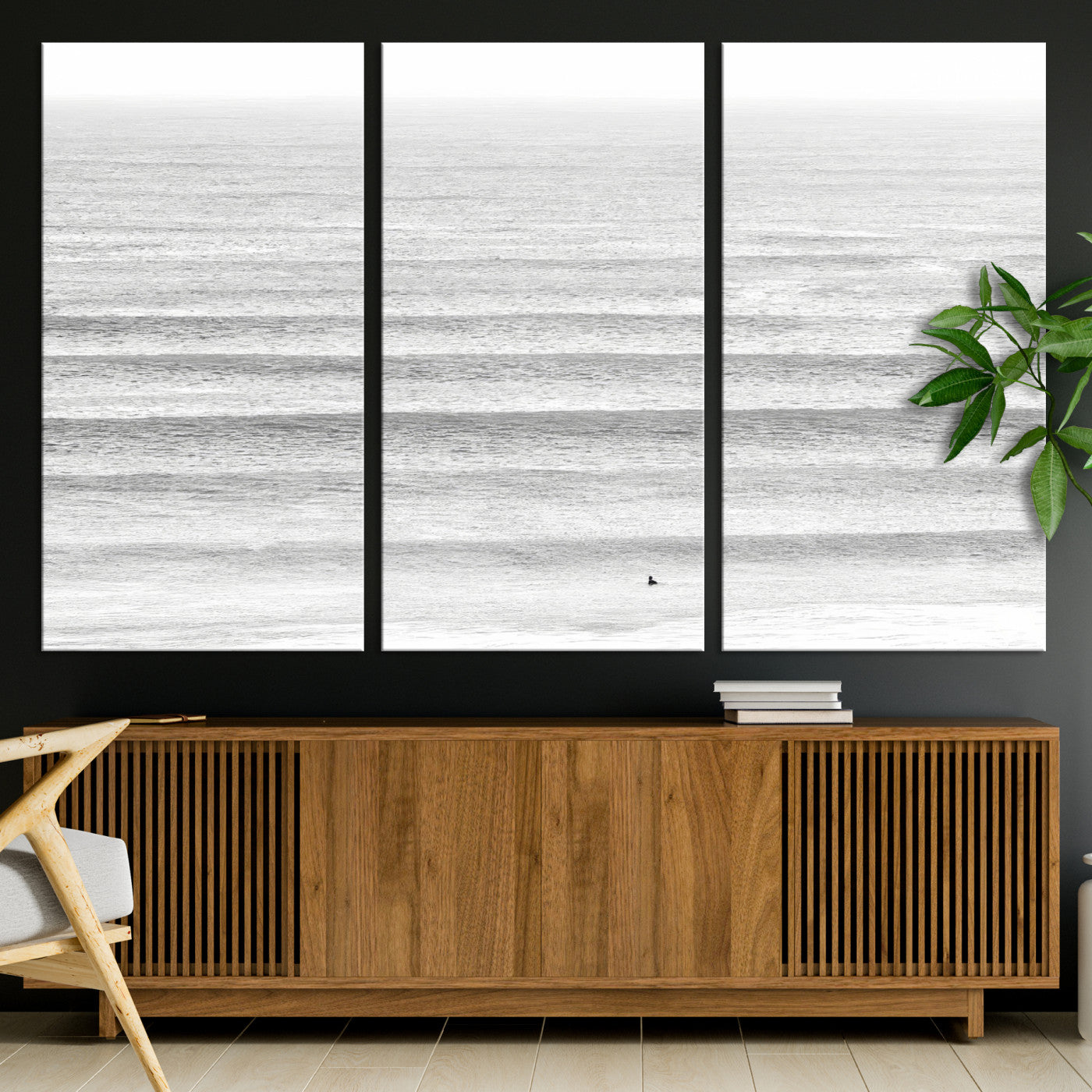 Monochrome photo of a lone surfer in calm layered waves, perfect for minimalist coastal or moody ocean-inspired wall decoration.