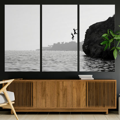 Black and white canvas of two figures cliff jumping into the sea, captured with moody tones, ideal for modern coastal or adventure-themed home decor.   2/2
