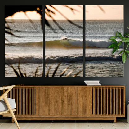 Photo of a surfer riding a golden hour wave at sunset, with tropical tones and dreamy light, perfect for tropical boho or coastal home decor.