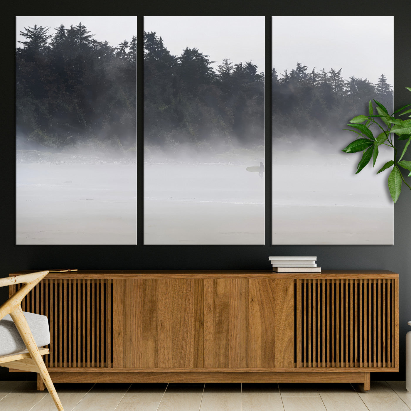 A lone surfer carrying a board through a misty shoreline, surrounded by dense trees and fog, creating a peaceful and mysterious coastal scene.