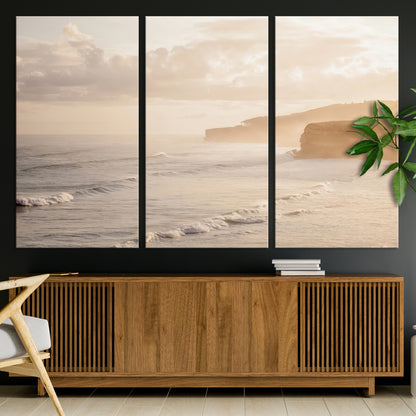 Golden hour seascape with misty cliffs and gentle waves rolling towards the shore, capturing a tranquil and warm coastal atmosphere.