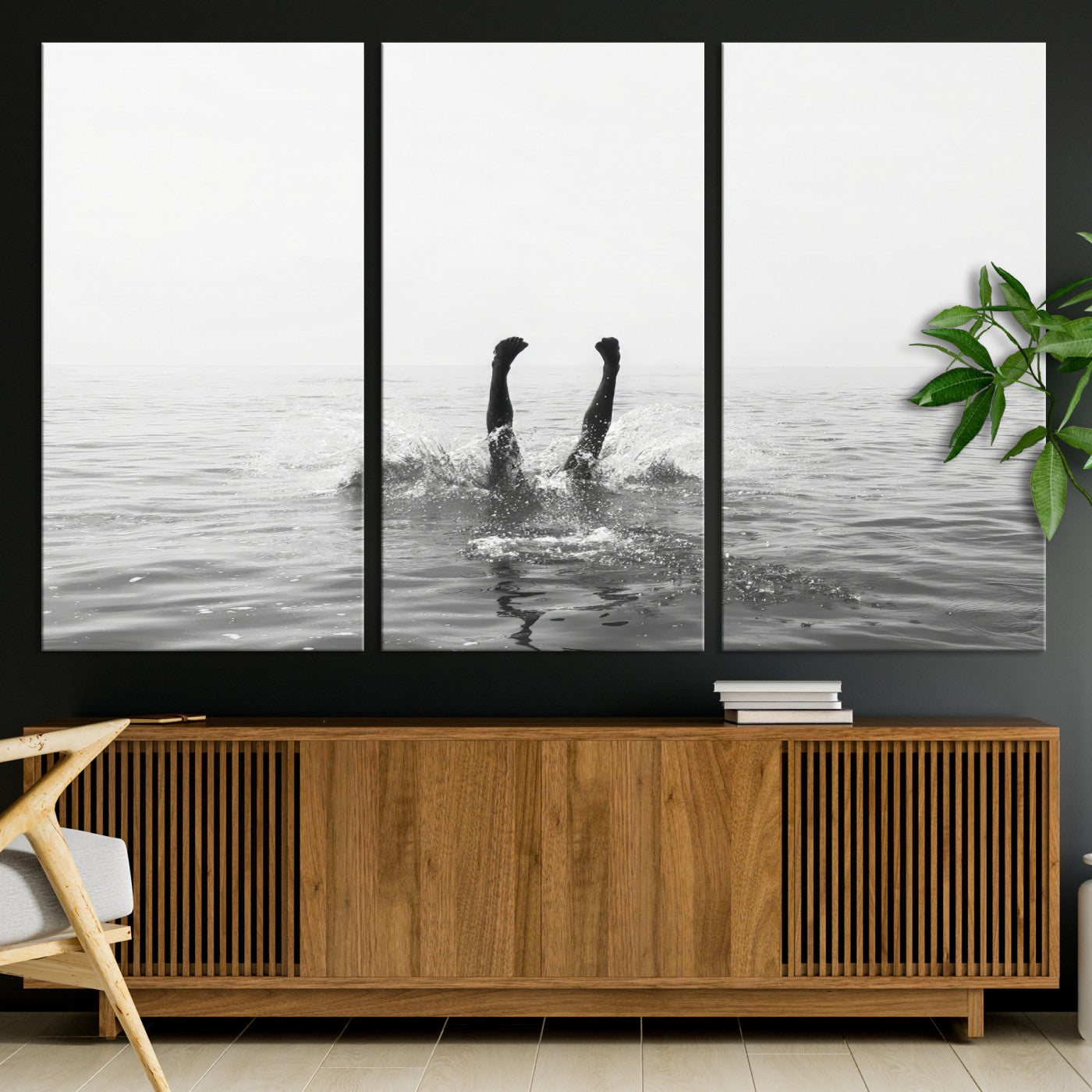 A black and white minimalist water scene capturing a playful splash as a swimmer dives upside down, creating a carefree and artistic aquatic aesthetic.