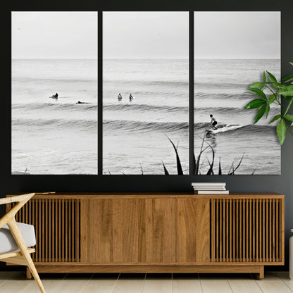 Monochrome canvas of surfers on calm ocean waves, ideal for minimalist coastal or beach-inspired interior decor.