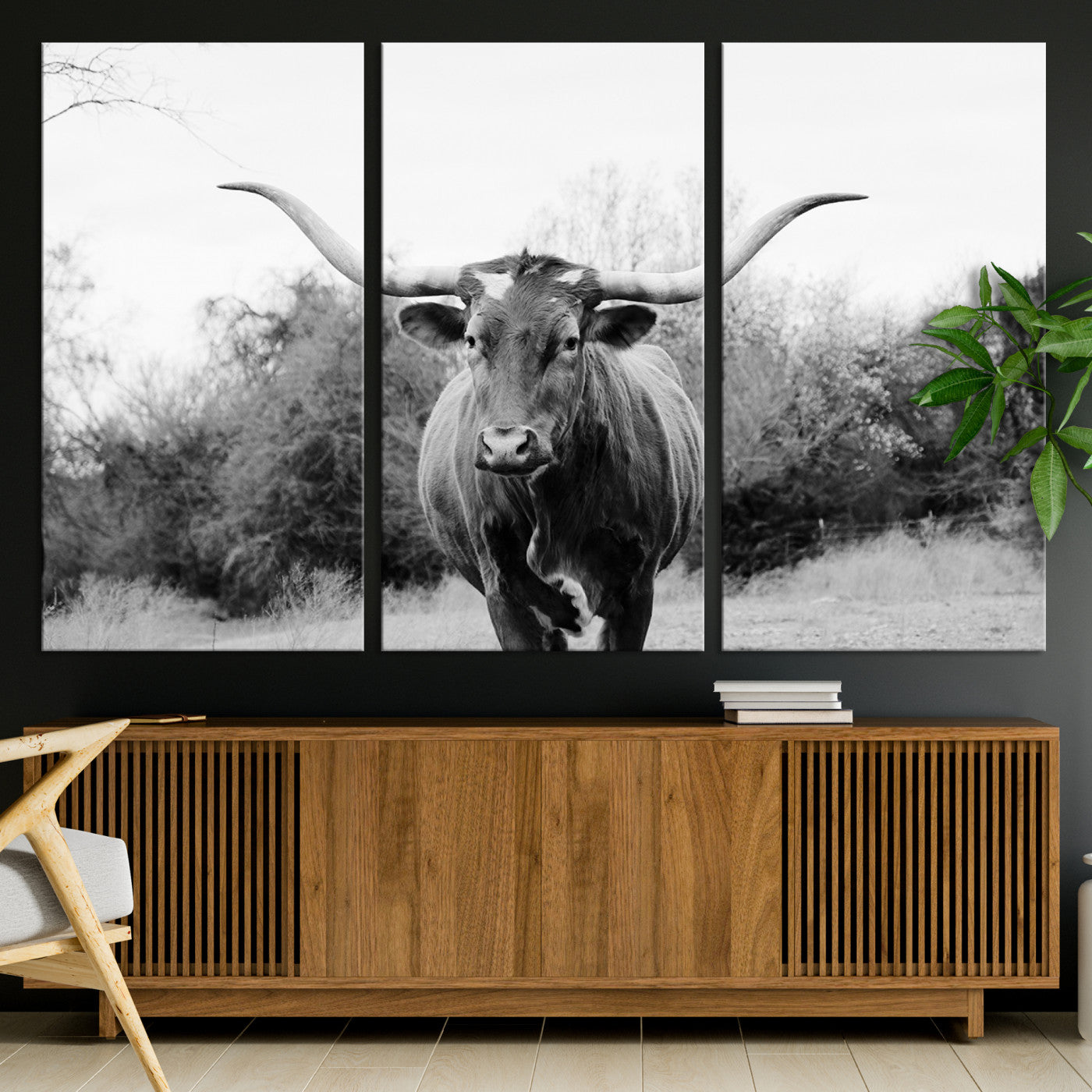 Black and white photo of a longhorn cow in a field, perfect for rustic farmhouse or western-themed interior wall decoration.