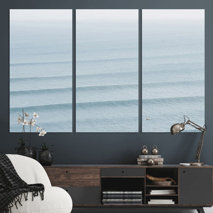 Framed canvas of repeating ocean waves with a distant solo surfer, ideal for minimalist ocean or calm coastal wall decor.