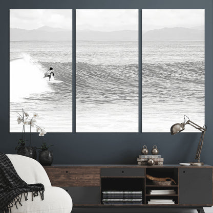 Monochrome photo of a surfer riding a wave with distant mountains, ideal for coastal motion or black and white surf-themed wall decor.