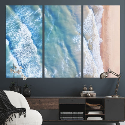 Aerial photo of soft blue waves meeting sandy shore, perfect for modern coastal or beach-themed decor with a light and tranquil aesthetic.