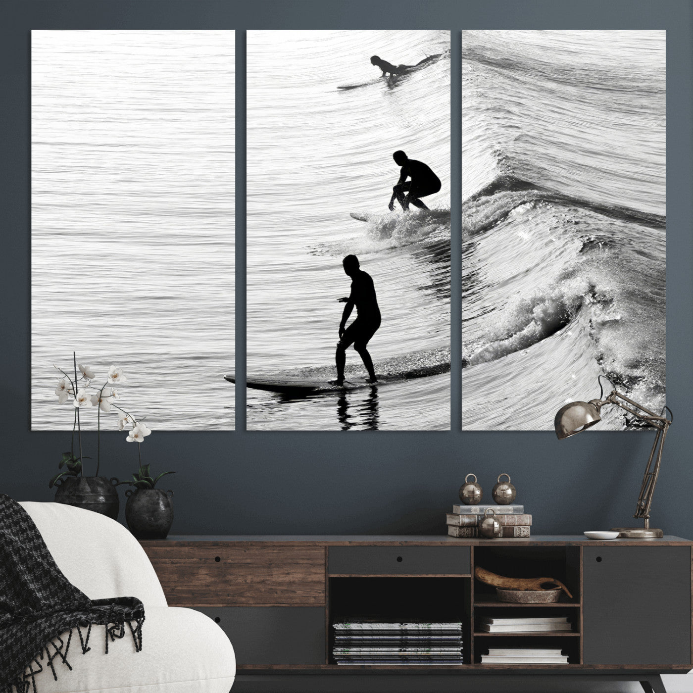 Black and white photo of surfers riding waves in a moody, high-contrast scene, ideal for modern coastal or surf-inspired home decor.