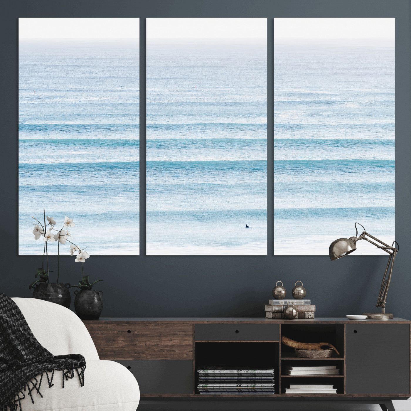 Minimalist ocean view with soft blue waves and a lone surfer, creating a serene and airy coastal aesthetic, perfect for tranquil home decor.