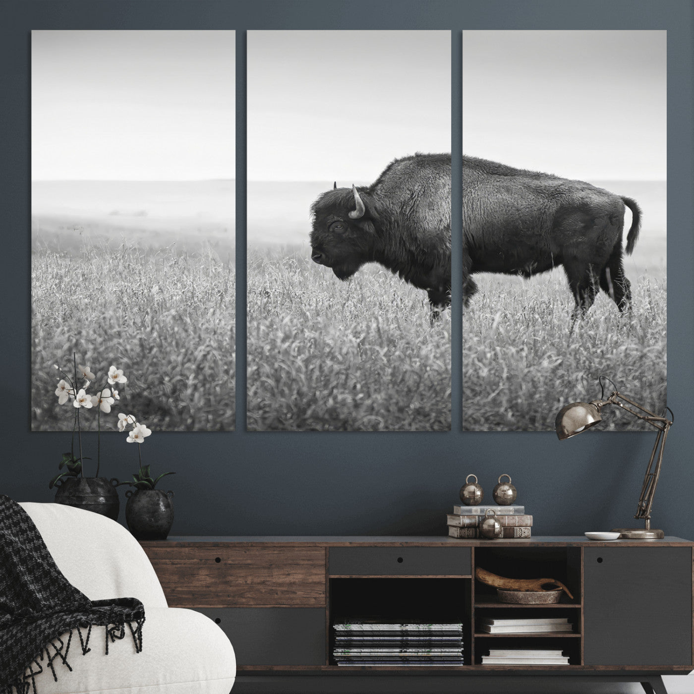 A black and white photograph of a majestic bison standing in a vast grassy prairie, evoking a sense of wilderness and strength.