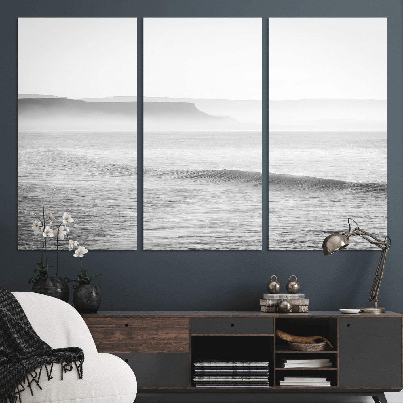 A black and white minimalist seascape featuring soft rolling waves and misty distant cliffs, creating a serene and timeless coastal atmosphere.