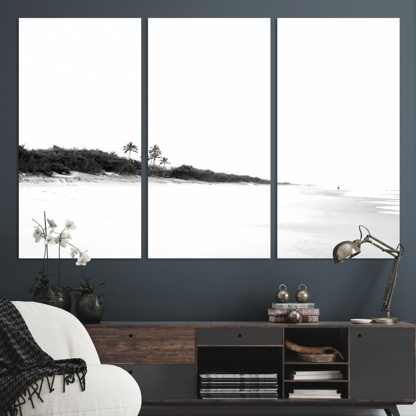A black and white minimalist coastal scene with a vast open beach, distant palm trees, and a lone figure walking along the shoreline, evoking serenity and solitude.