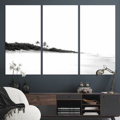 A black and white minimalist coastal scene with a vast open beach, distant palm trees, and a lone figure walking along the shoreline, evoking serenity and solitude.