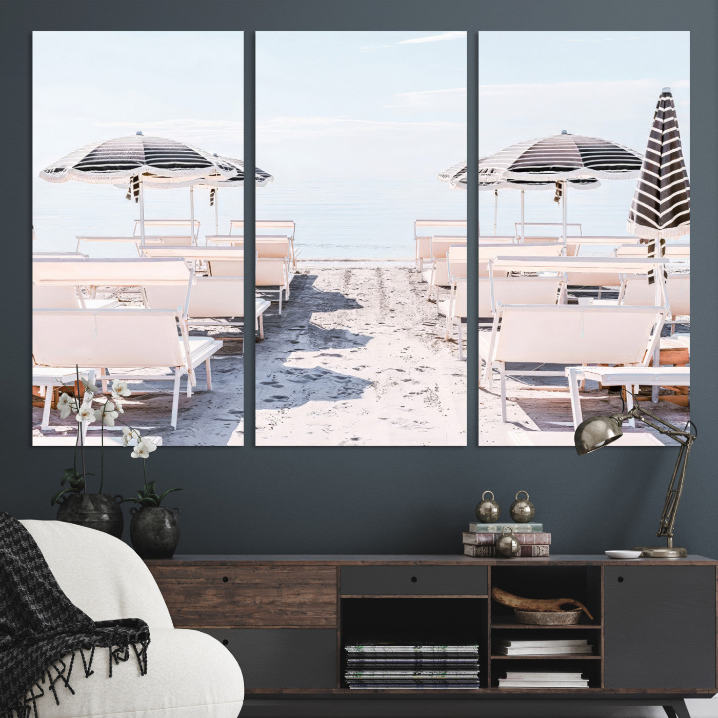 A serene minimalist beach scene featuring striped umbrellas, soft pastel sand, and an elegant lounge setup, creating a tranquil and stylish coastal retreat.