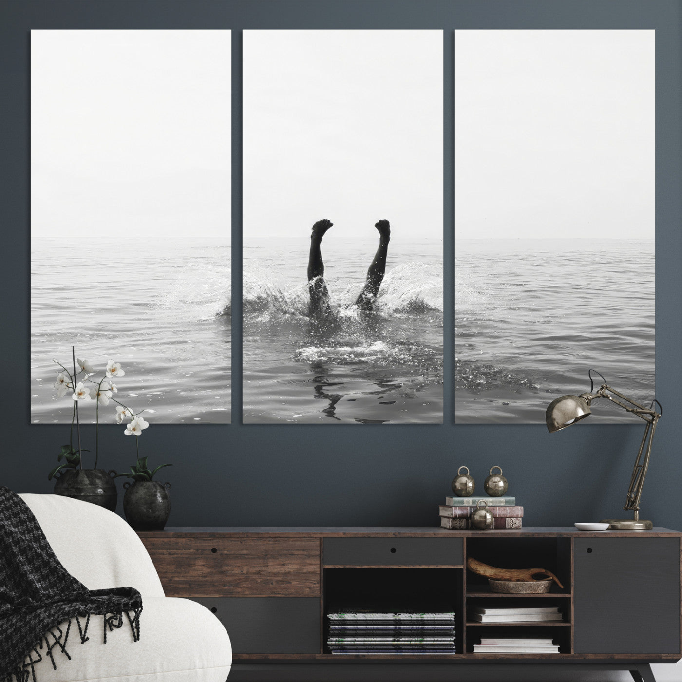 A black and white minimalist water scene capturing a playful splash as a swimmer dives upside down, creating a carefree and artistic aquatic aesthetic.