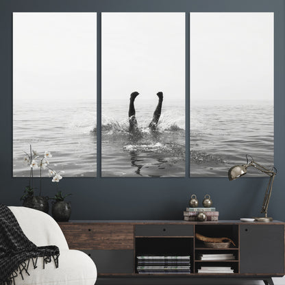 A black and white minimalist water scene capturing a playful splash as a swimmer dives upside down, creating a carefree and artistic aquatic aesthetic.