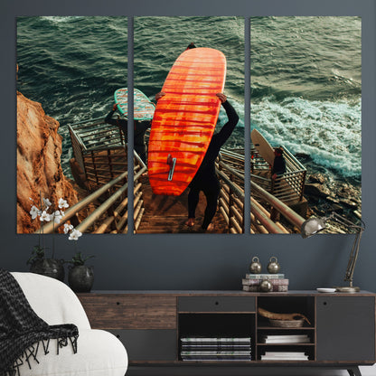 A surfer carrying a bold orange surfboard down a rugged staircase toward the ocean, bathed in golden hour light, capturing the energy of coastal adventure.