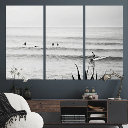Monochrome canvas of surfers on calm ocean waves, ideal for minimalist coastal or beach-inspired interior decor.